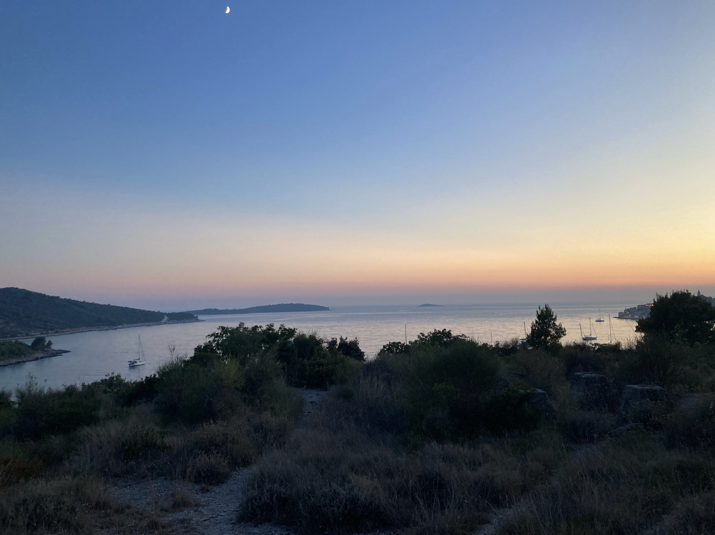 Adriatische Küstenstraße oberhalb von Primošten bei Sonnenuntergang mit Blick auf die Adria